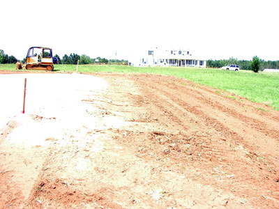Finished pad with Top soil stock pile spread out on the side slopes to limit the amount of fill