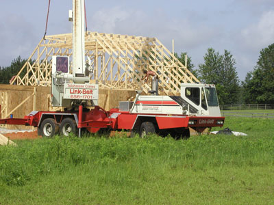 the framers tacking the trusses in place as the crane brings them one after another..