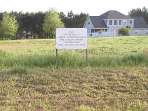 Lot with for sale sign on it prior to clearing